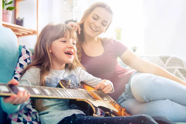 Anya és lánya otthon, játék gitár és ének — Stock Fotó