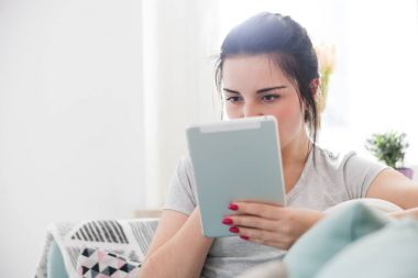 Genç kadın rahat koltukta otururken PC tablet kullanma