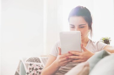 Genç kadın rahat koltukta otururken PC tablet kullanma