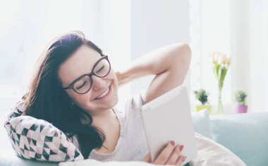 Rahat kadın rahat koltukta otururken PC tablet kullanma