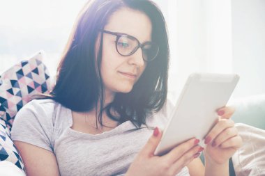 Rahat kadın rahat koltukta otururken PC tablet kullanma