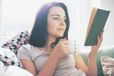 Kahve içme ve evde kitap okurken rahat kadın