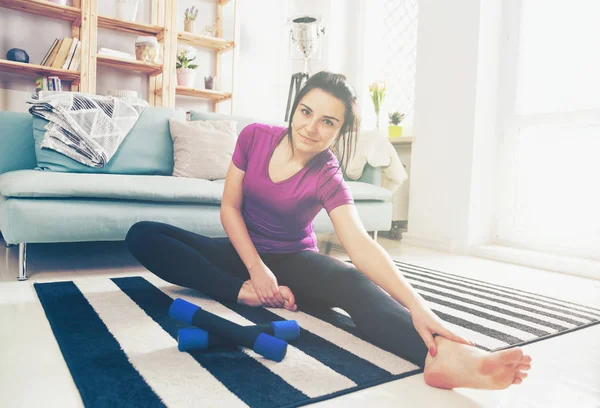 Młoda kobieta ćwiczenia na dywanie w domu wnętrz — Zdjęcie stockowe