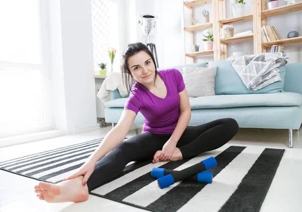 Młoda kobieta ćwiczenia na dywanie w domu wnętrz — Zdjęcie stockowe