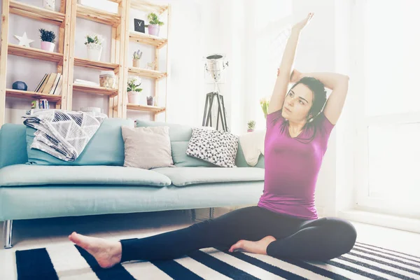 Jeune femme exerçant sur le tapis à l'intérieur de la maison — Photo