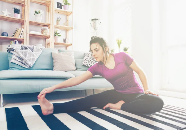 Jeune femme exerçant sur le tapis à l'intérieur de la maison — Photo