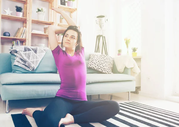 Jeune femme exerçant sur le tapis à l'intérieur de la maison — Photo