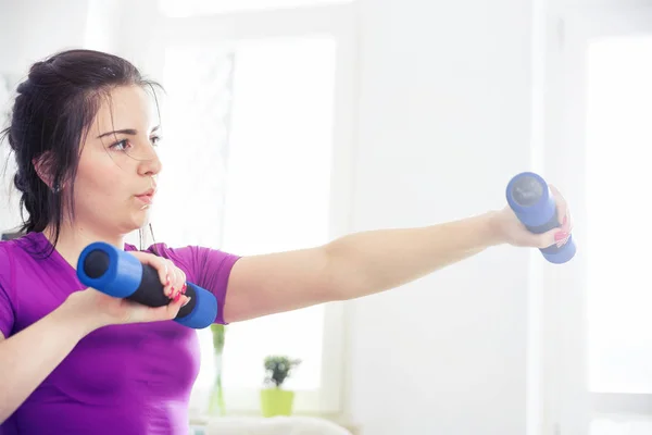 Young woman exercising at home interior
