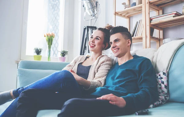 Aimer couple sur canapé à la maison regarder la télévision et rire — Photo