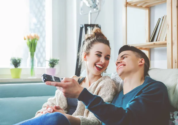 Aimer couple sur canapé à la maison regarder la télévision et rire — Photo