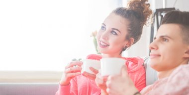 Genç çift rahatlatıcı ve evde kanepede sabah kahve içme