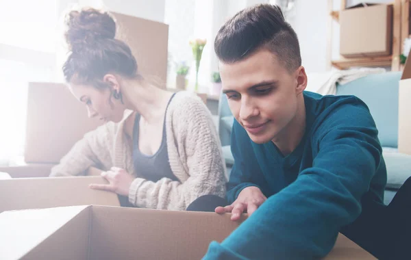 Casal se movendo em nova casa e desempacotando caixas — Fotografia de Stock