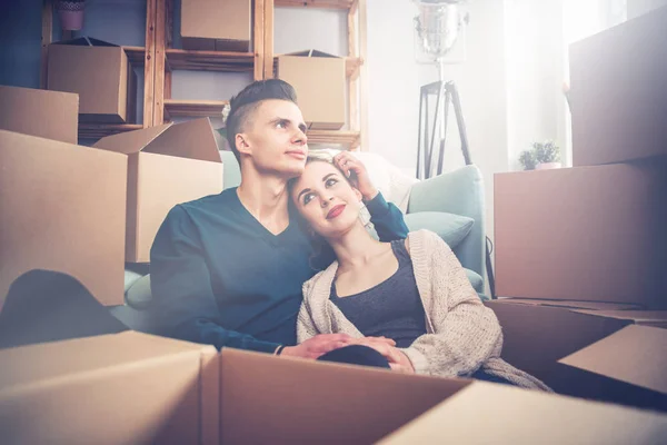Casal se movendo em nova casa e relaxante no chão depois de desempacotar caixas — Fotografia de Stock