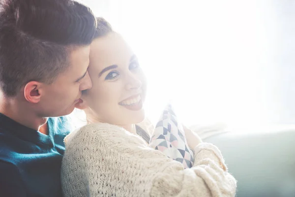 Loving young couple hugging and lying on sofa at home — Stock Photo, Image