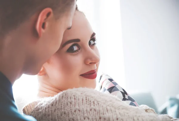 Aimer jeune couple étreignant et couché sur le canapé à la maison — Photo