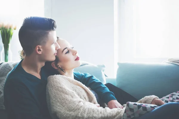 爱的年轻夫妇拥抱和躺在沙发上在家里 — 图库照片