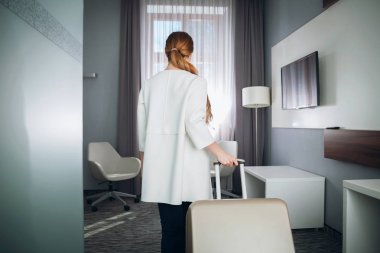 Modern otel odasında bavul çekerek kadın