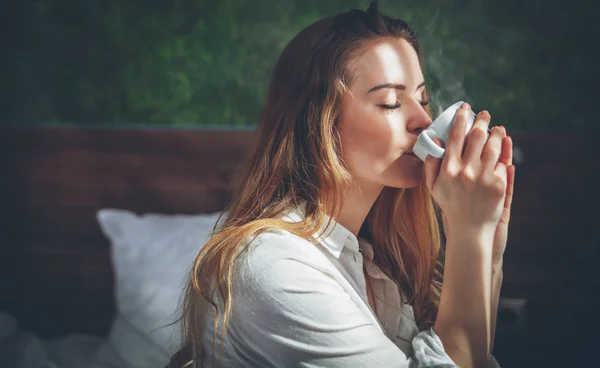 Vacker kvinna i modern lägenhet dricka kaffe efter vakna — Stockfoto