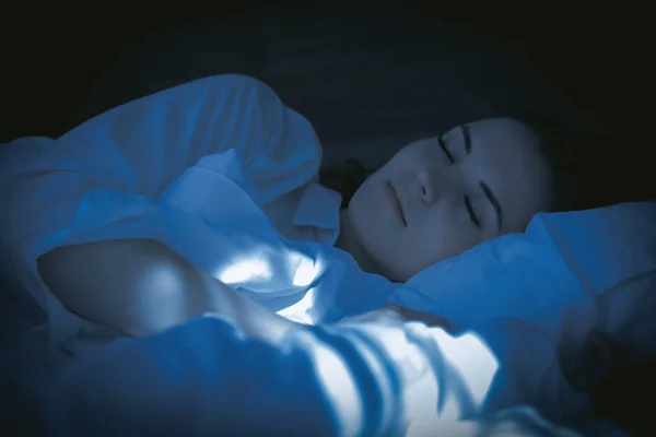 Jolie femme dans un appartement moderne dormant paisiblement la nuit — Photo