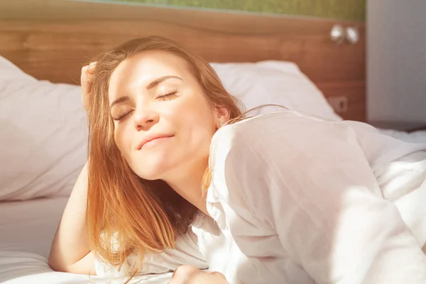 漂亮的女人在床上醒来之后微笑起来的现代公寓 — 图库照片