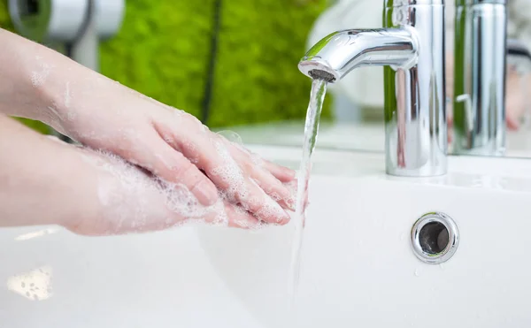 Femme se laver les mains dans la salle de bain moderne — Photo