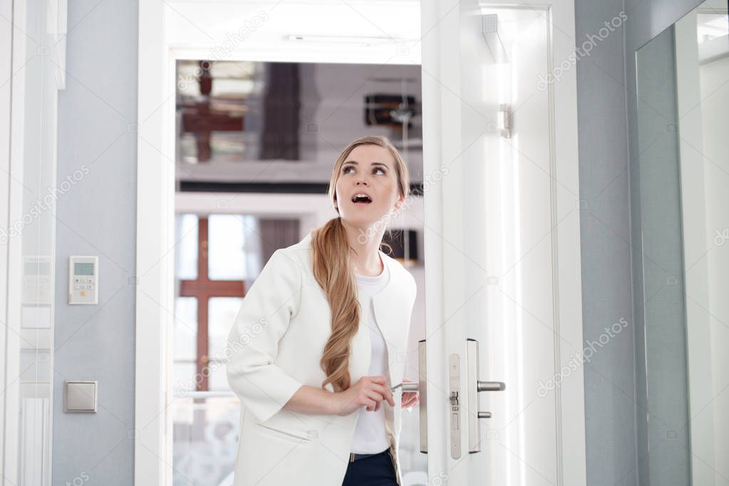 Delighted woman opening door at modern hotel room