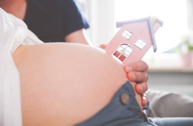 Hamile oryantal küçük ev, kavramı yeni ev ve ailesi ile yakın çekim