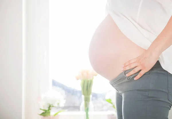 Těhotná žena doma zblízka břicho — Stock fotografie