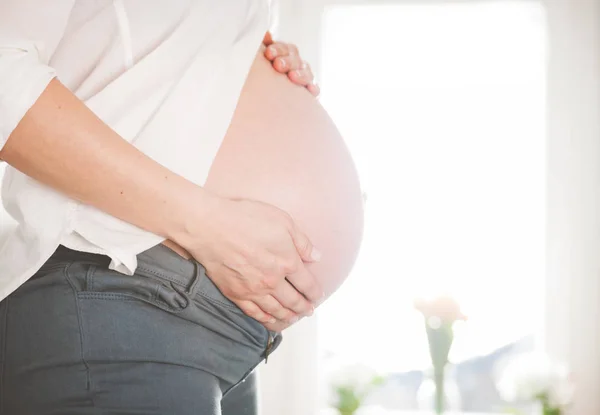 Беременная женщина дома крупным планом живота — стоковое фото