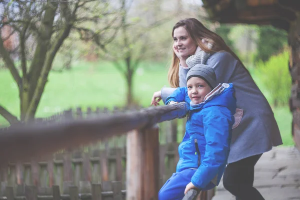 Mutter und Sohn auf der Terrasse eines alten Holzhauses im Grünen — Stockfoto