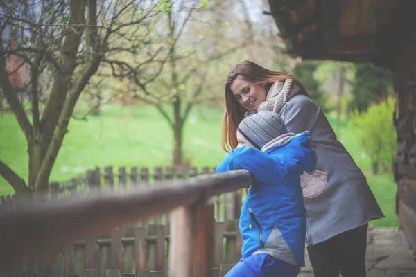 Mutter und Sohn auf der Terrasse eines alten Holzhauses im Grünen — Stockfoto