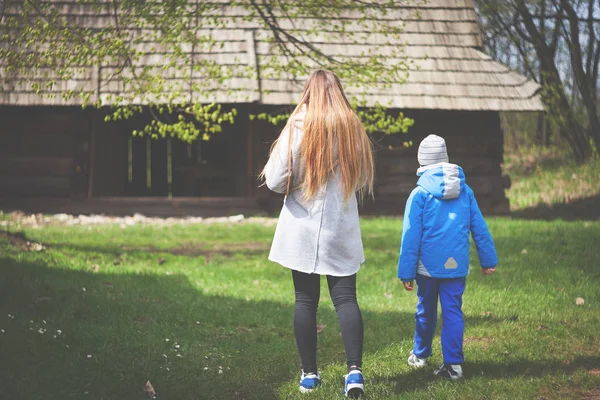 Mother and son walking near old wooden barn in the countryside — Stock Photo, Image