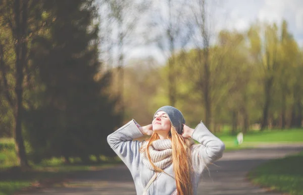 Mujer feliz disfrutando del sol en el parque a principios de primavera —  Fotos de Stock