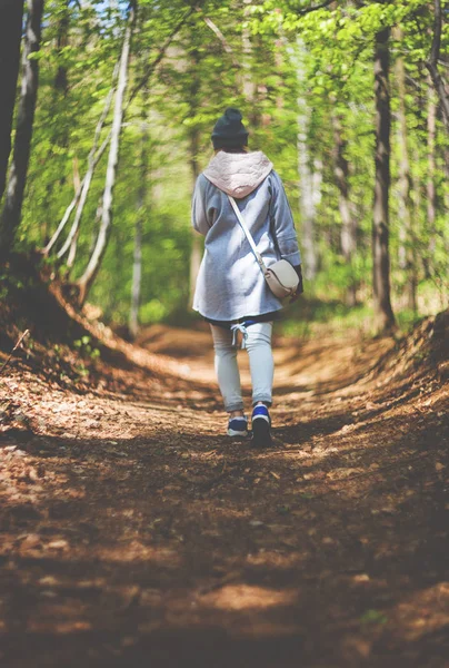 Junge Frau allein im Frühjahrswald unterwegs — Stockfoto