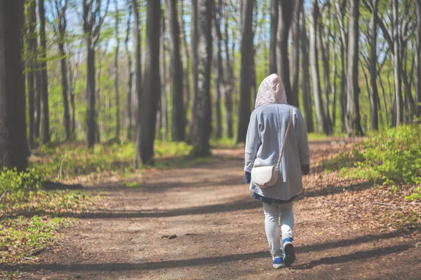 Giovane donna che cammina da sola nella foresta all'inizio della primavera — Foto Stock