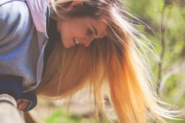 Parkta yürüyüş sırasında uzun sarı saçlı genç kadın