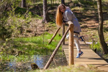 Kadın parkta yürüyüş sırasında doğanın keyfini