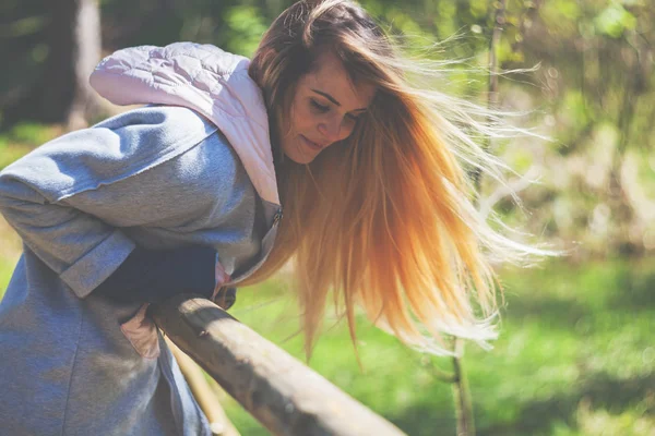 Jovem com longos cabelos loiros durante a caminhada no parque — Fotografia de Stock