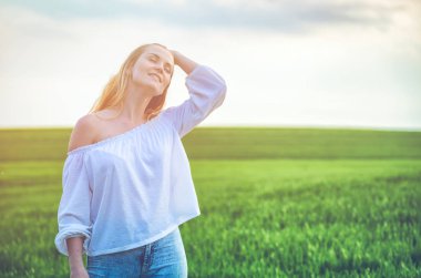 Güneşli bir gün, yeşil alanda mutlu gülümseyen kadın