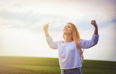 Güneşli bir gün, yeşil alanda mutlu gülümseyen kadın