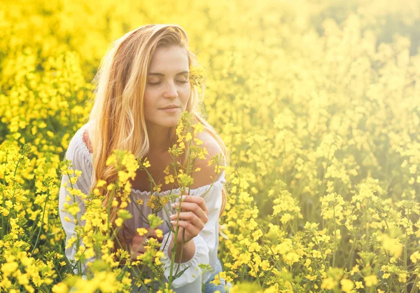 Usmívající se žena v žlutou řepkové pole na slunečný den — Stock fotografie