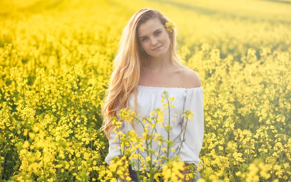 Lachende vrouw in geel koolzaad veld op zonnige dag — Stockfoto