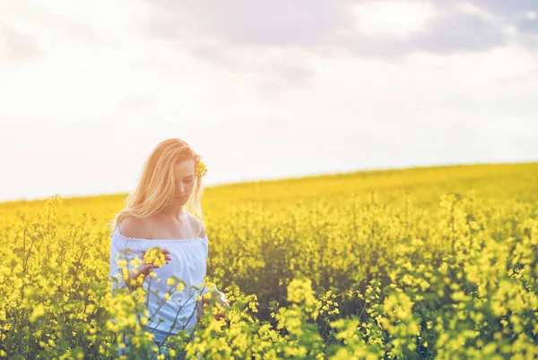 Güneşli bir gün sarı kolza tohumu alanında gülümseyen kadın — Stok fotoğraf