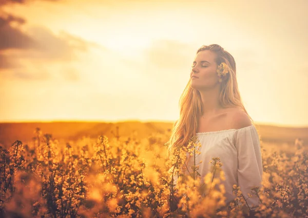 在日落时微笑黄色油菜花田的女人 — 图库照片