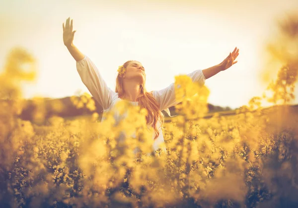 Feliz mulher sorridente no campo de colza amarelo ao pôr do sol conceito de liberdade — Fotografia de Stock