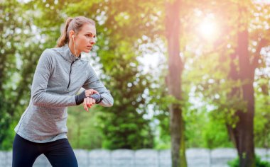 Başlamadan önce akıllı saatini kurmayı çalıştıran atletik kadın