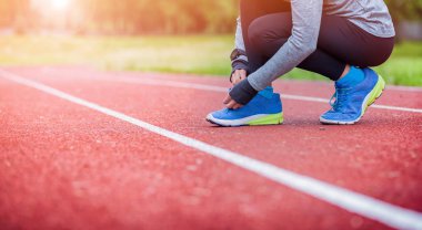 Atletik kadın Koşu Ayakkabı bağcıklarımı, fitness aksesuarları bağlayan yolda