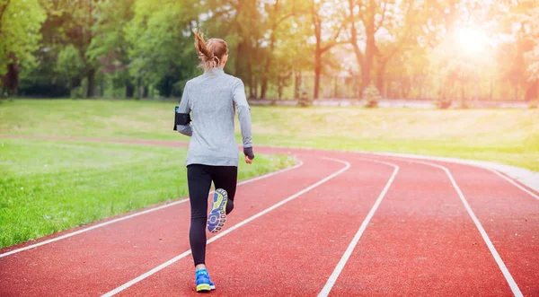 Athletic woman running on track back view, healthy lifestyle — Stock Photo, Image