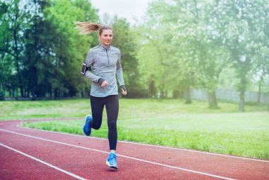 Akıllı telefon app, yaşam tarzı ile yolda çalıştıran atletik kadın