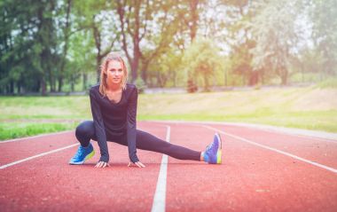 Atletik kadın koşu parkuru daha önce eğitim, sağlıklı yaşam tarzı germe